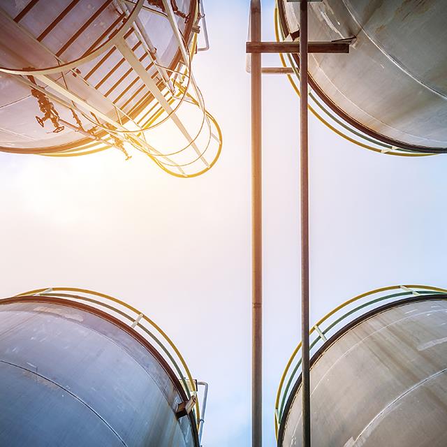 Chemical Processing Industry Lubricants – Ground-to-Sky View from Middle of Four Storage Tanks – Krytox™