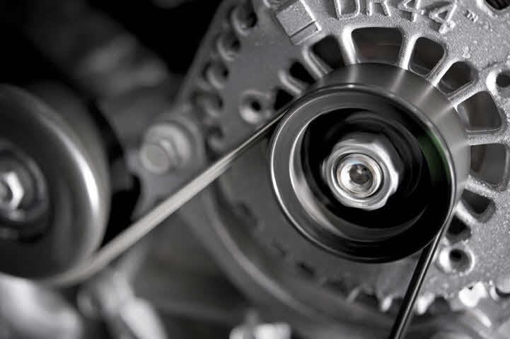 An image of an automotive flywheel with gears wrapped with a rubber belt.