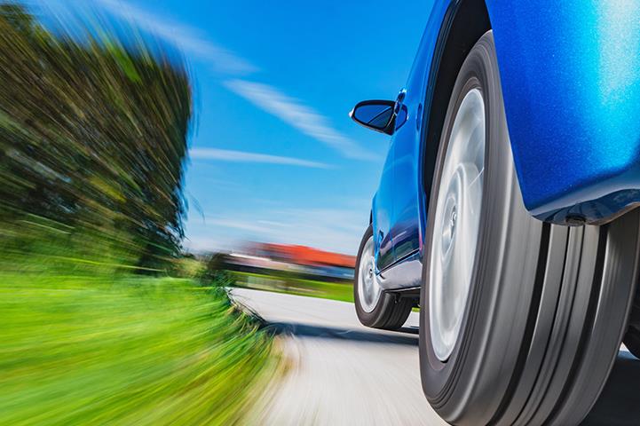Lubrication for Lightweighting – Blue Car Speeding on Rural Road – Krytox™