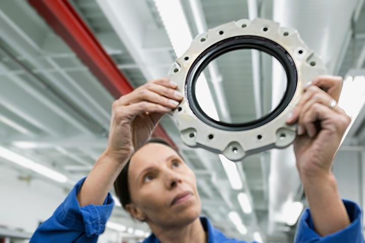 female helicopter mechanic examining a disk